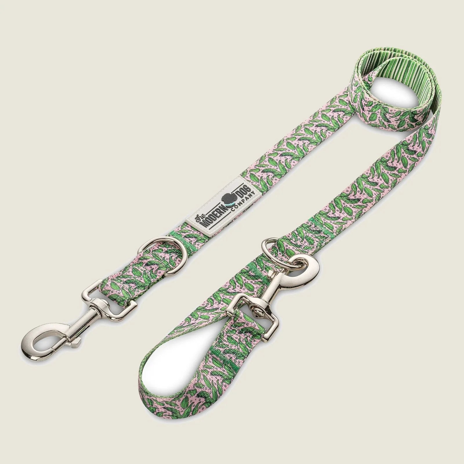 Stylish green dog leash with pink tropical patterns, featuring dual swivel bolt snaps for adjustable lengths.
