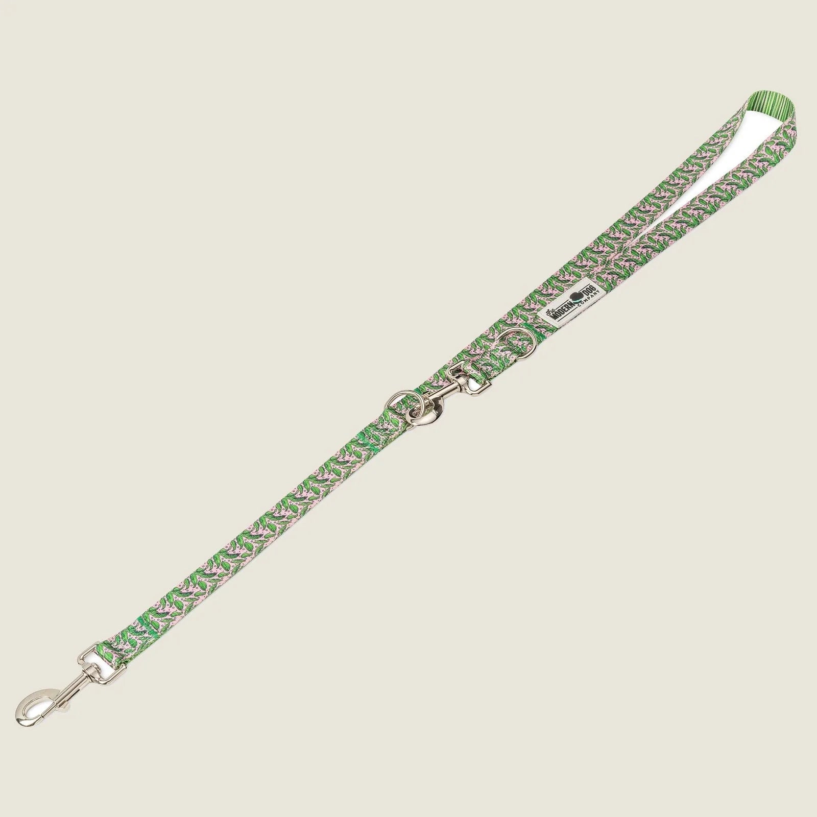 Green and pink patterned dog leash with a dual swivel bolt snap and multiple D-ring attachments for accessories.