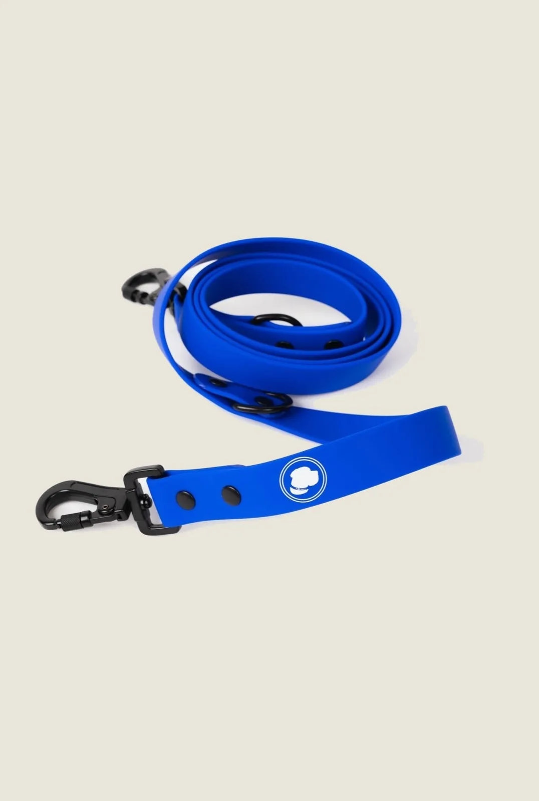 Royal blue adjustable dog leash with black clips, featuring a logo and designed for all-weather use.