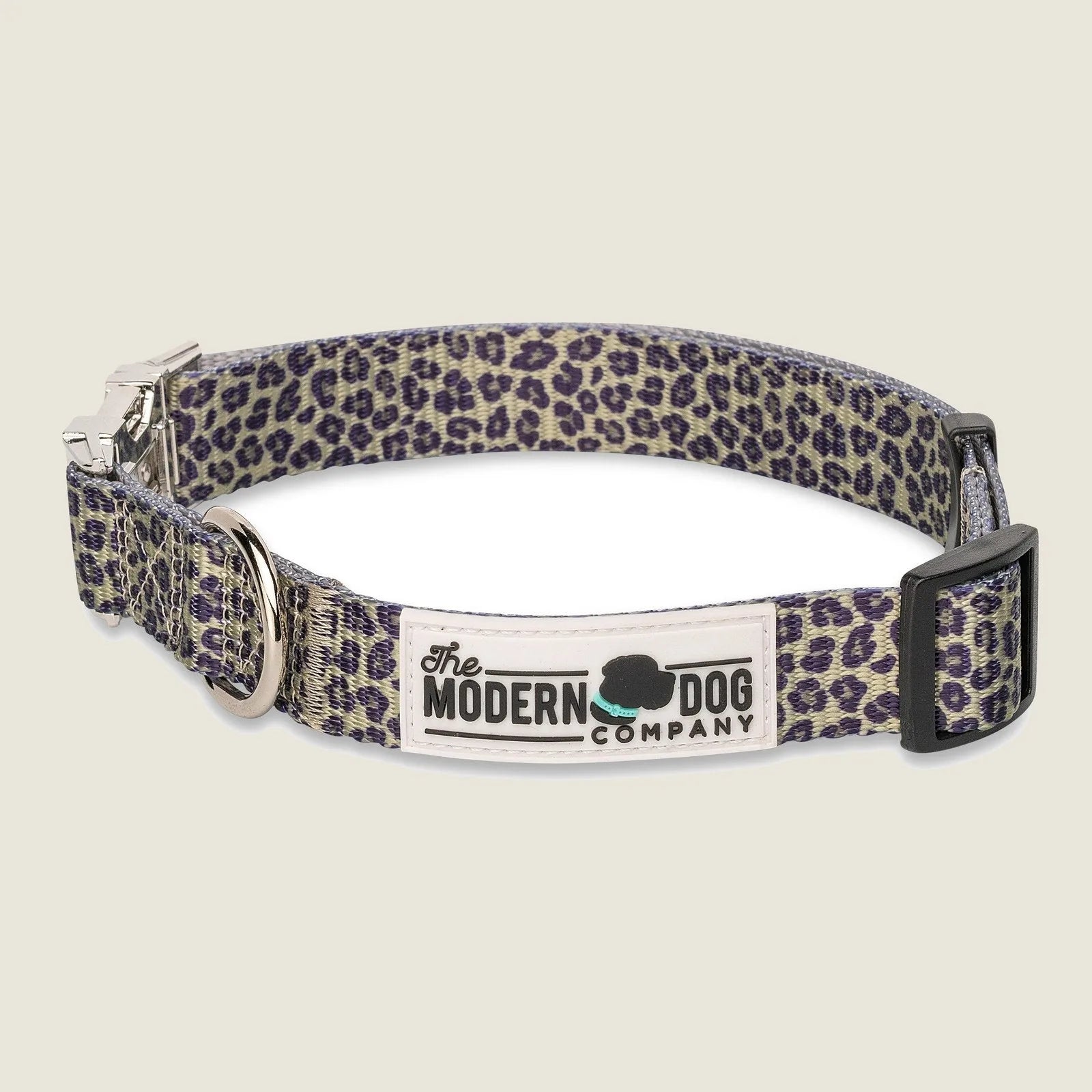 Adjustable dog collar in a purple leopard print design with a durable strap and metal D-ring for leash attachment.