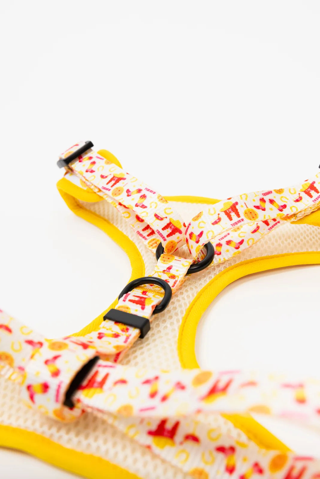 Stylish dog harness with a vibrant yellow trim and playful pattern of hot dogs and burgers on adjustable straps.