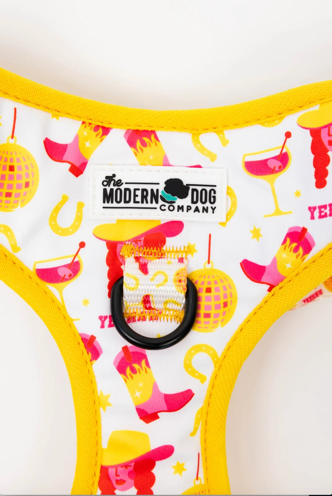 Adjustable dog harness featuring a colorful cowboy-inspired pattern with yellow trim and double D-ring for leashes.