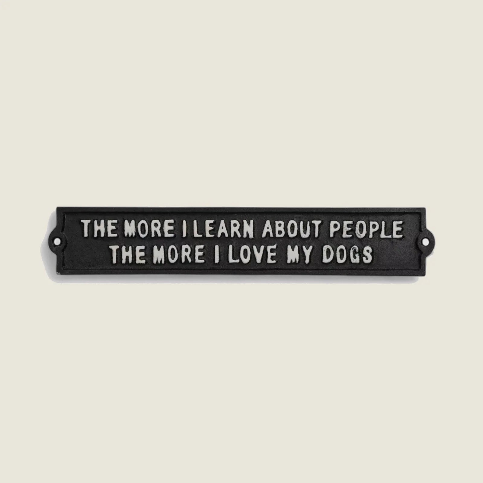 Cast iron wall plaque in black featuring the phrase "The More I Learn About People, The More I Love My Dogs."