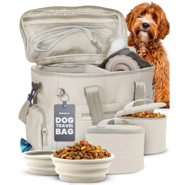 Light beige dog travel bag with collapsible bowls, food containers, and a fluffy dog in the background.