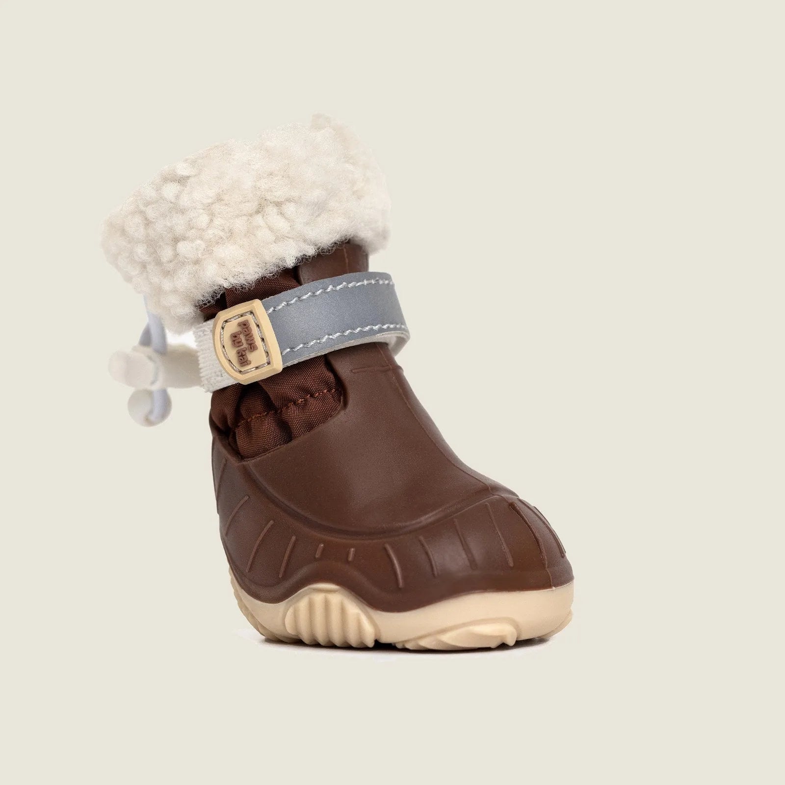 Brown waterproof dog snow boot with plush sherpa lining and gray strap for secure fit, designed for winter adventures.
