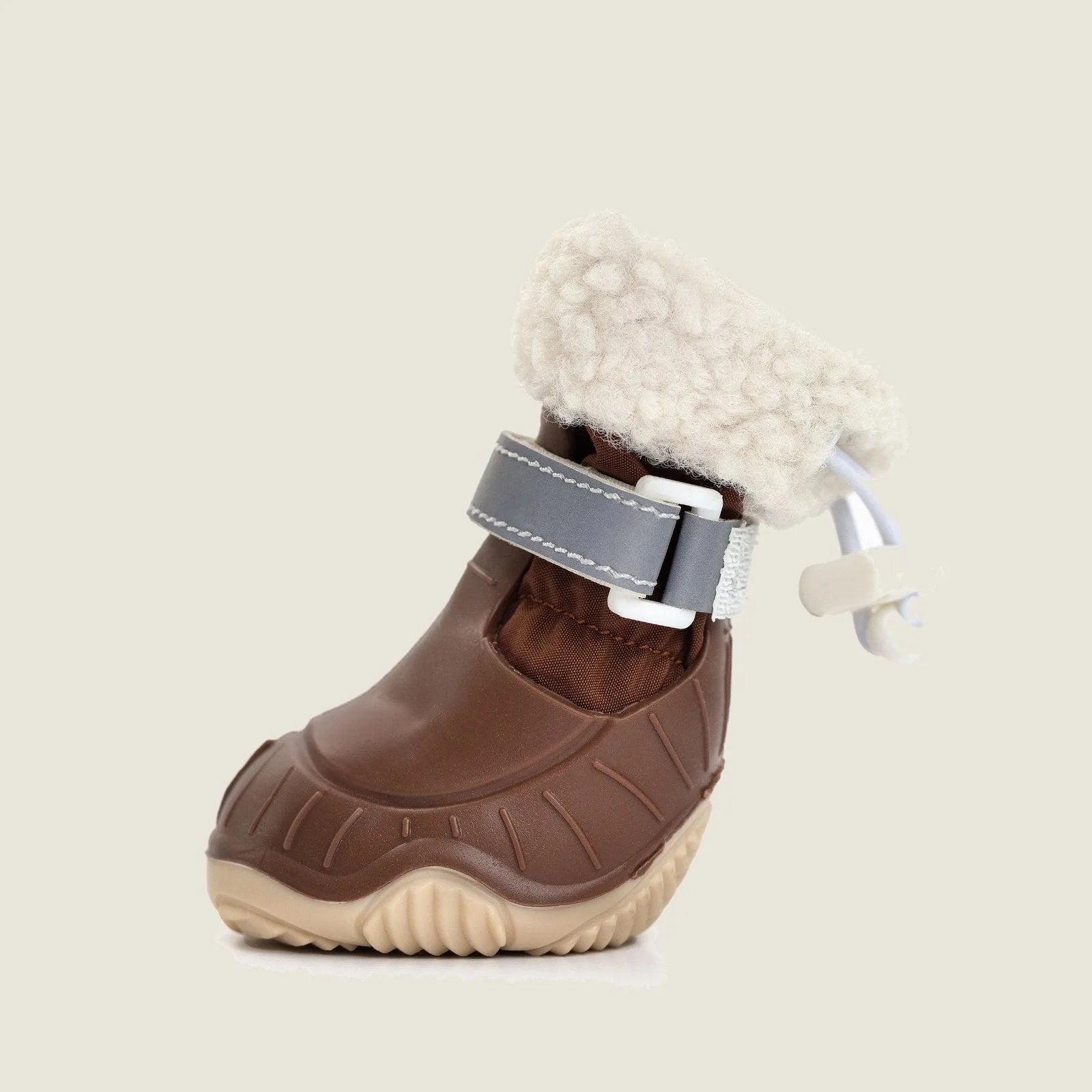 Brown dog snow boot with plush sherpa lining, adjustable strap, and rugged sole for winter protection and comfort.