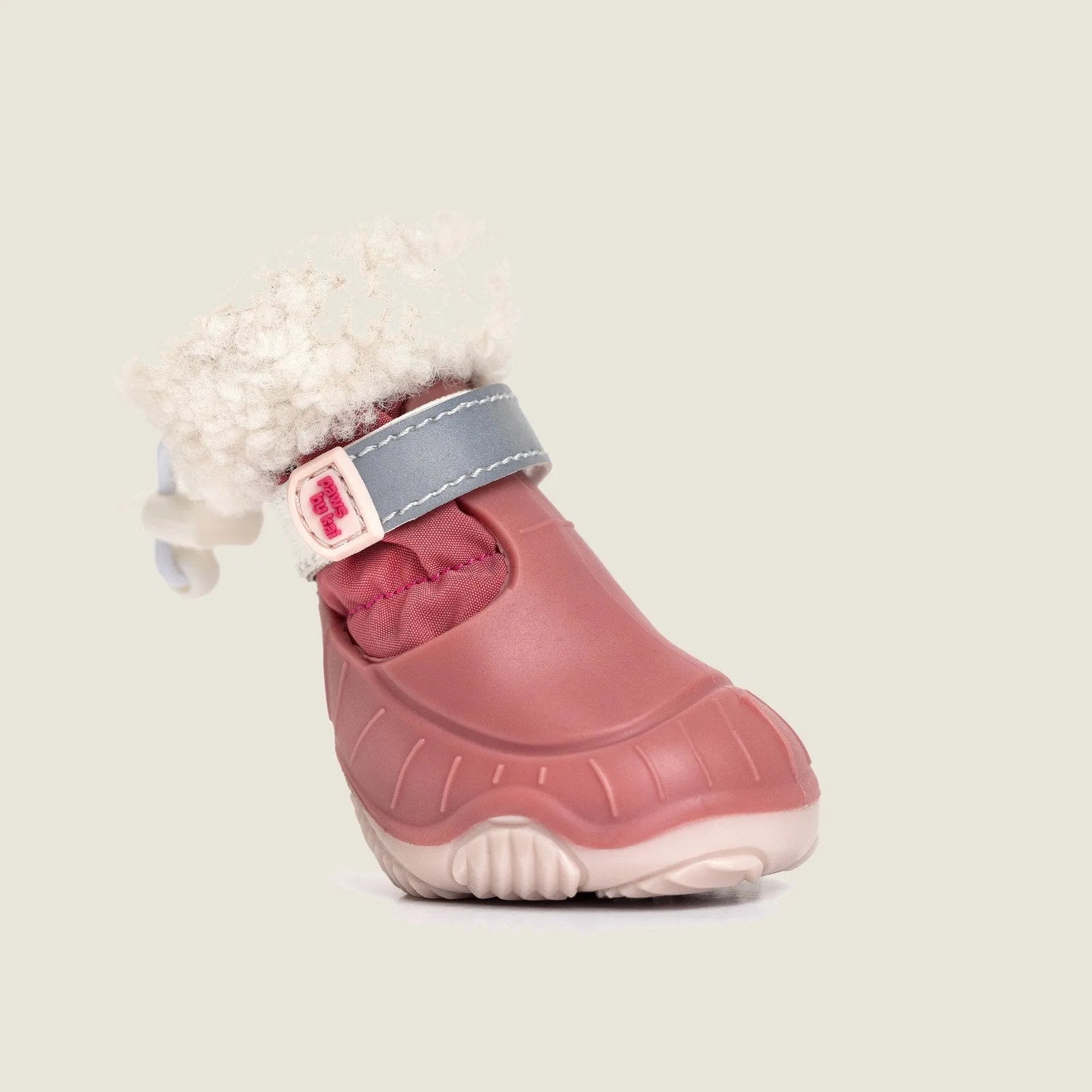 Pink dog snow boot with a plush sherpa cuff, adjustable strap, and rugged sole for winter protection.