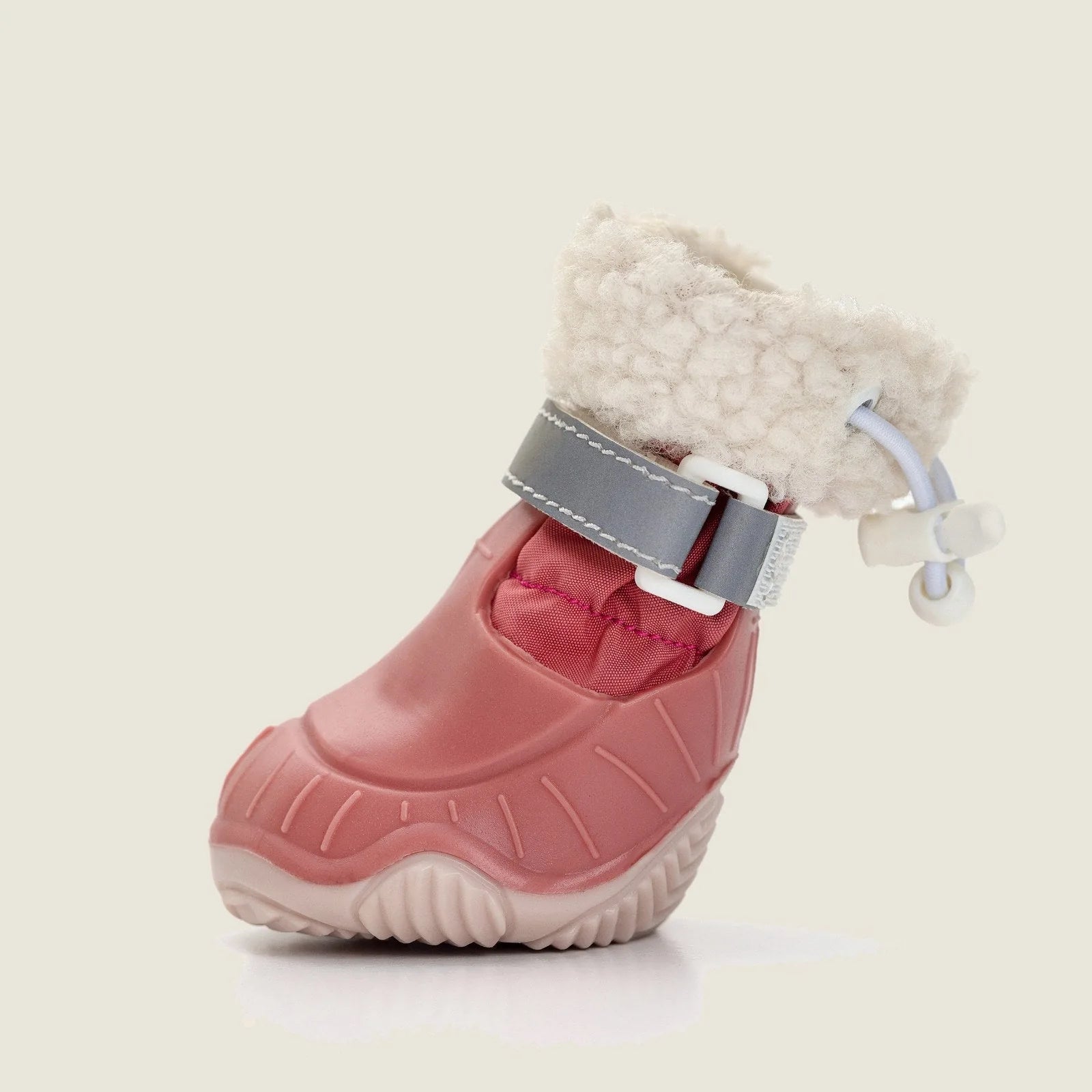 Pink waterproof dog boot with a plush sherpa lining and adjustable strap, ideal for winter walks.