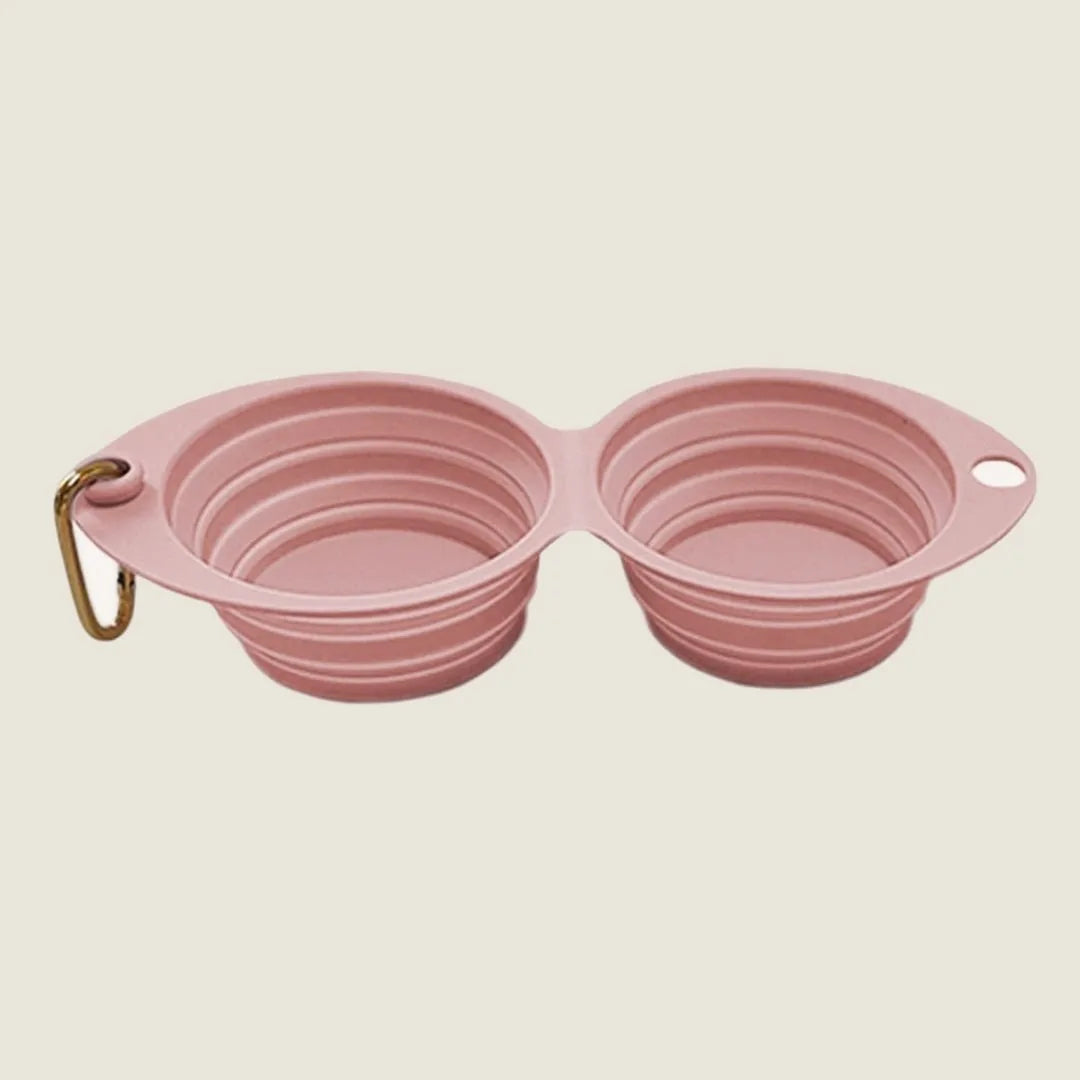 Collapsible pink double pet bowl with a clip, designed for easy travel and outdoor use.