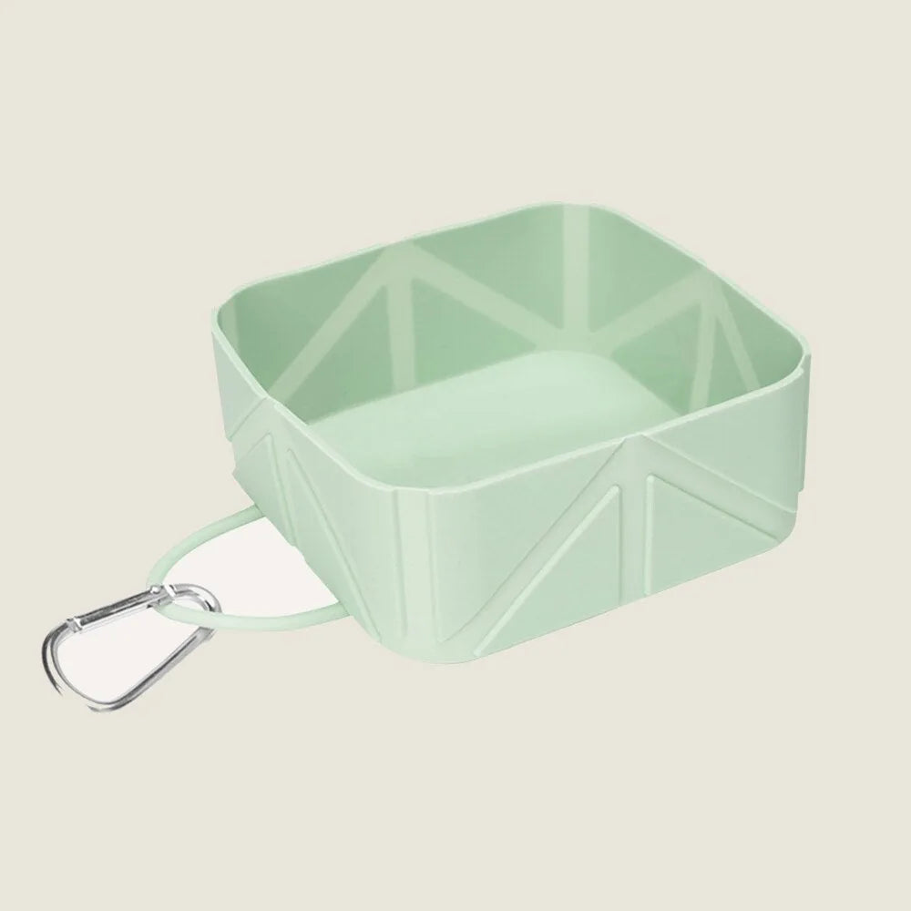 Mint green foldable pet food and water bowl with a carabiner for easy attachment, designed for travel convenience.