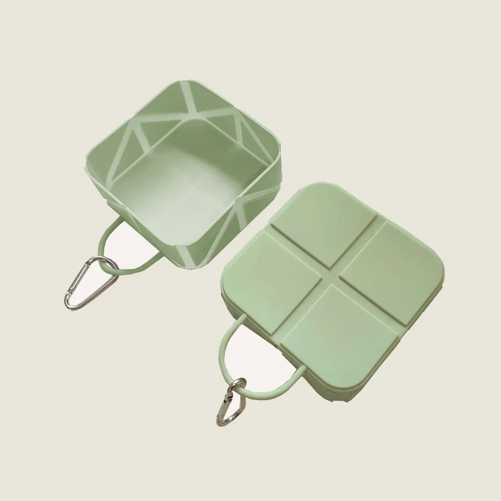 Mint green compact foldable pet food and water bowl with a carabiner, designed for travel and outdoor adventures.
