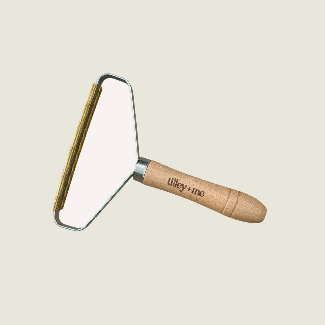 Eco-friendly pet hair lint remover with a beech wood handle and metal frame, designed for easy grooming.