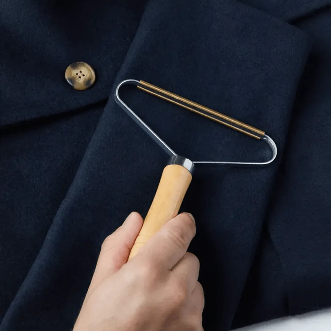 Beech wood lint remover in use on a dark fabric, effectively removing pet hair with its simple, eco-friendly design.
