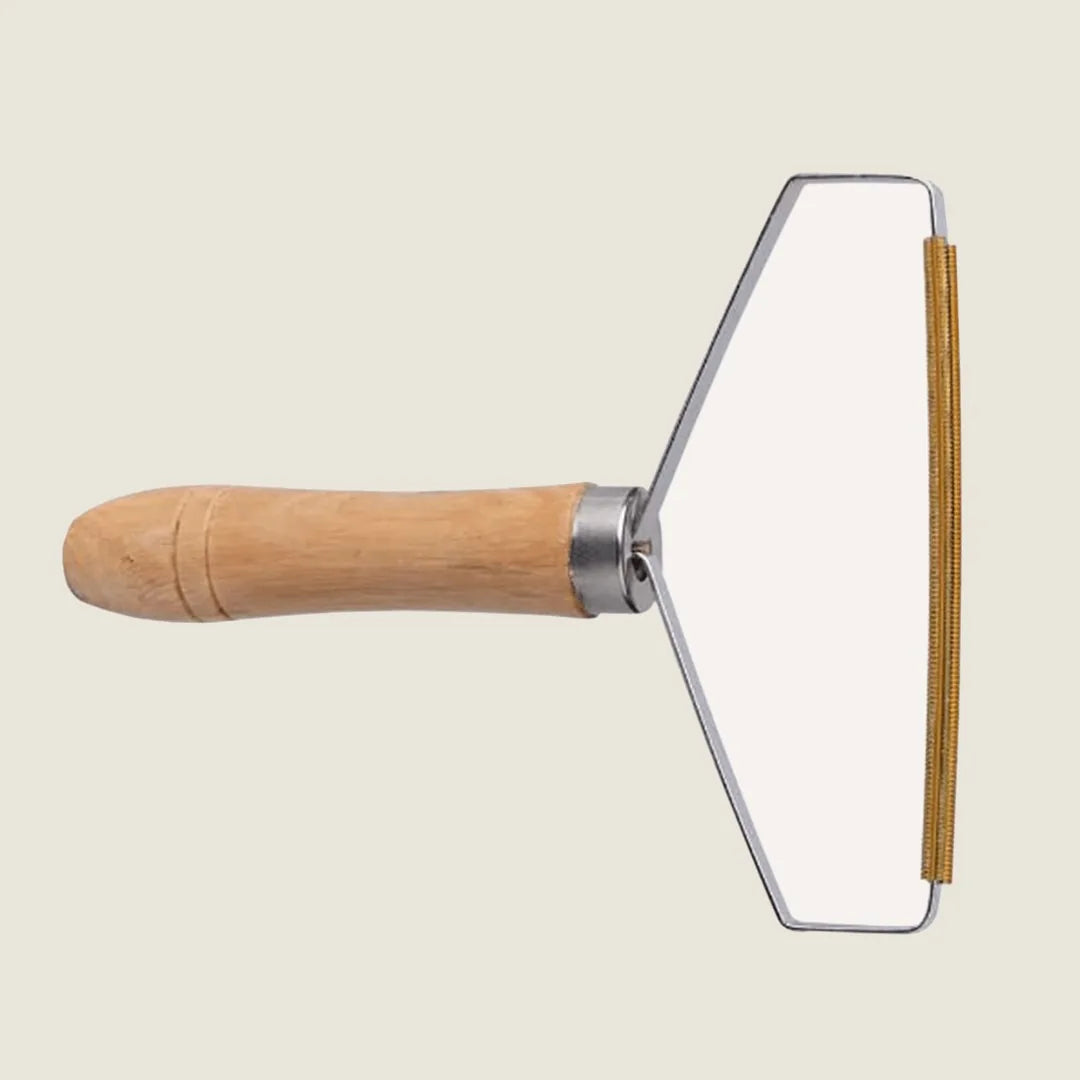 Beech wood lint remover with a sleek metal design, ideal for removing pet hair from fabrics and surfaces.