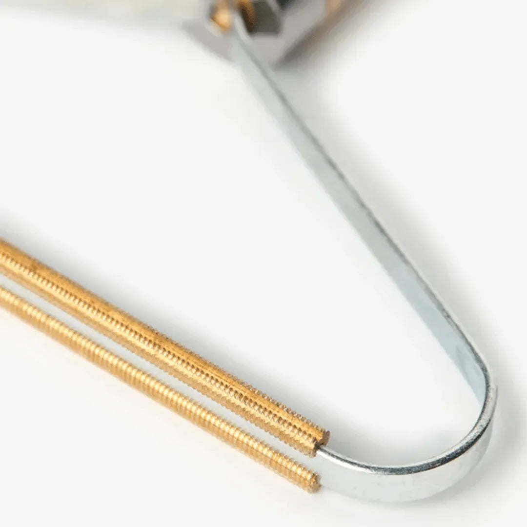 Close-up of a Tilley + Me beech wood lint remover with gold and silver metal components, ideal for pet hair removal.