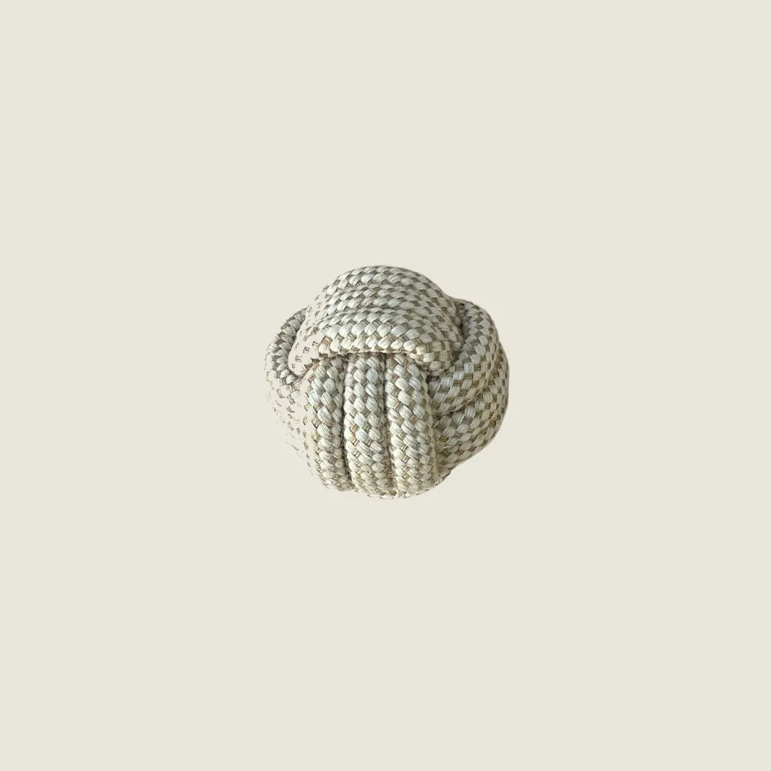 Durable hemp rope ball toy in a light beige color, designed for chewing and fetch games. Ideal for eco-conscious pet owners.