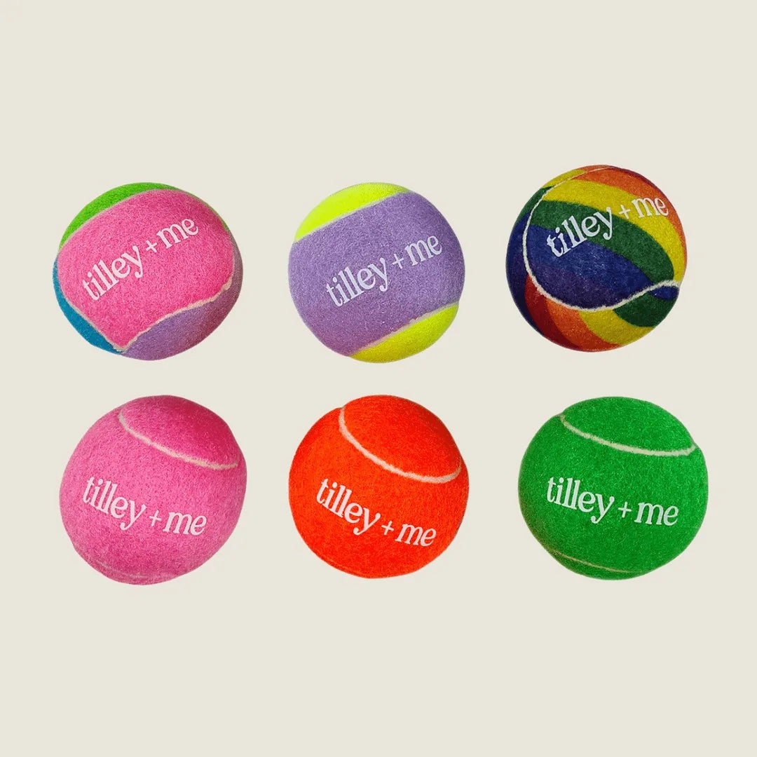 Colorful Tilley + Me tennis balls in pink, green, orange, purple, and rainbow patterns, perfect for dog playtime.