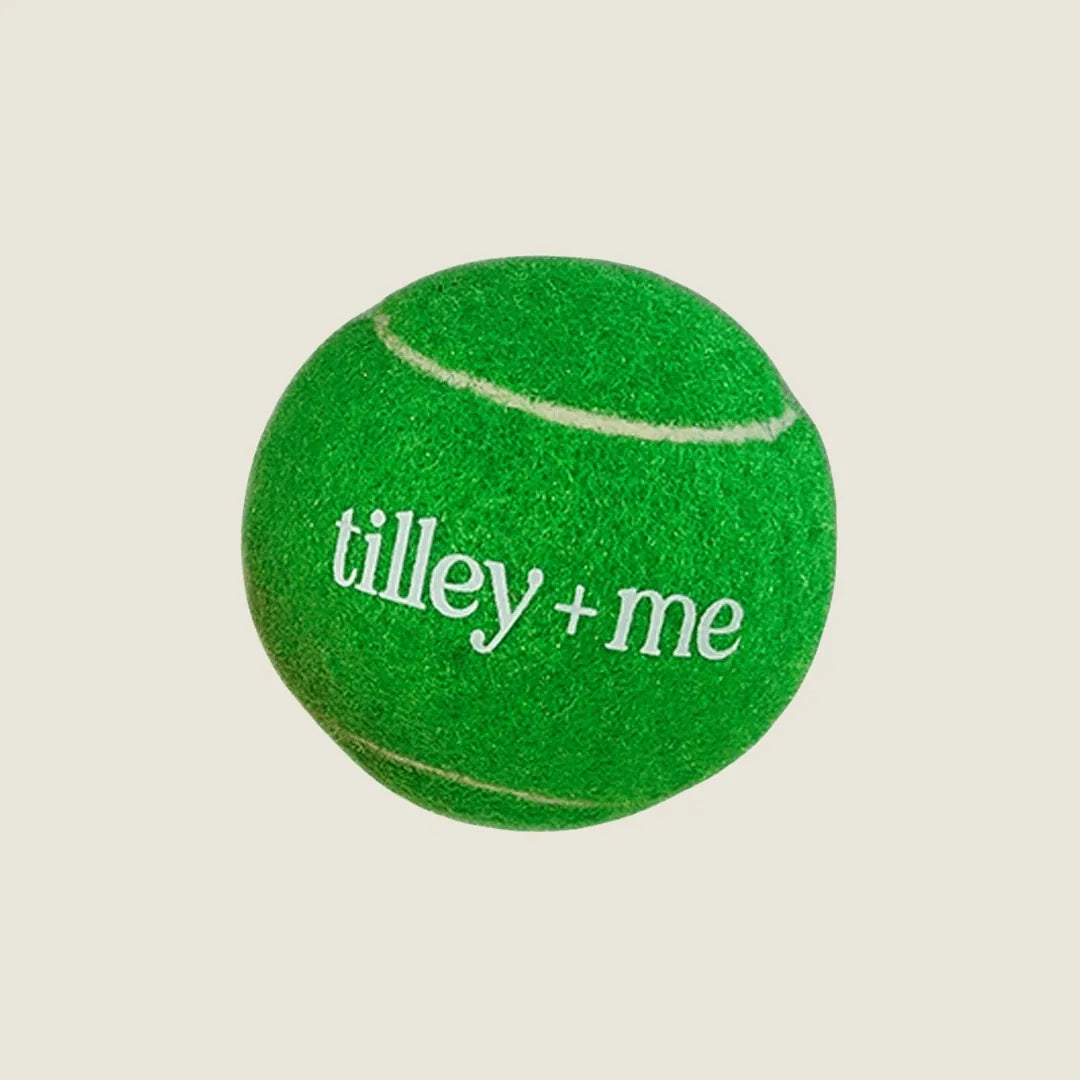 Bright green tennis ball for dogs with "tilley + me" printed, showcasing its soft, sustainable material design.