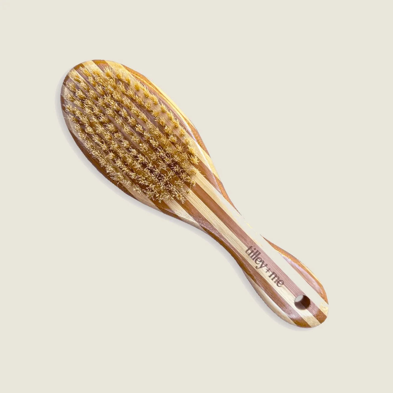 Two-sided pet brush with natural bristles and bamboo handle, designed for shedding and detangling dog's coat.