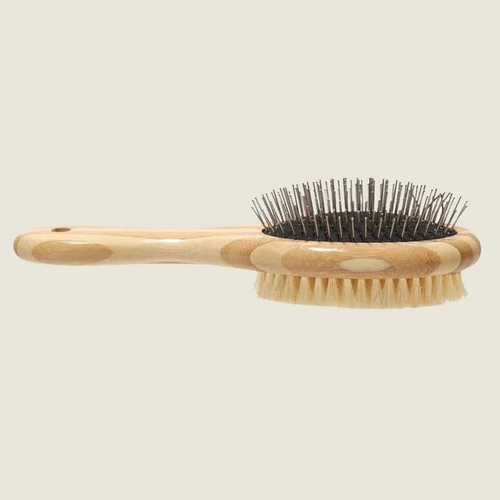 Two-sided dog brush with a natural bamboo handle, featuring bristles on one side and wire pins on the other.
