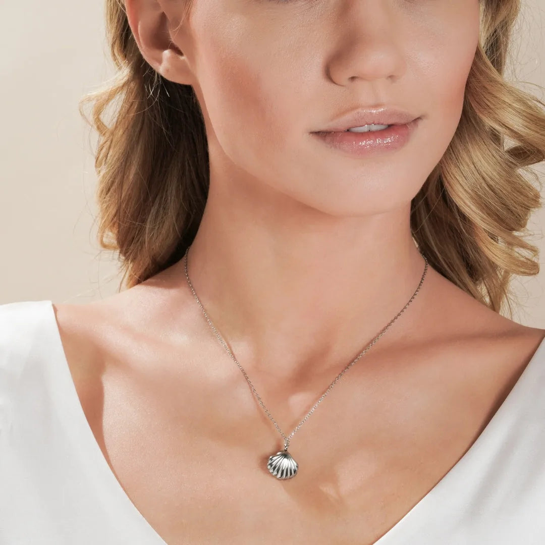 Silver shell-shaped cremation necklace worn on a woman's neck, symbolizing pet keepsake memories.