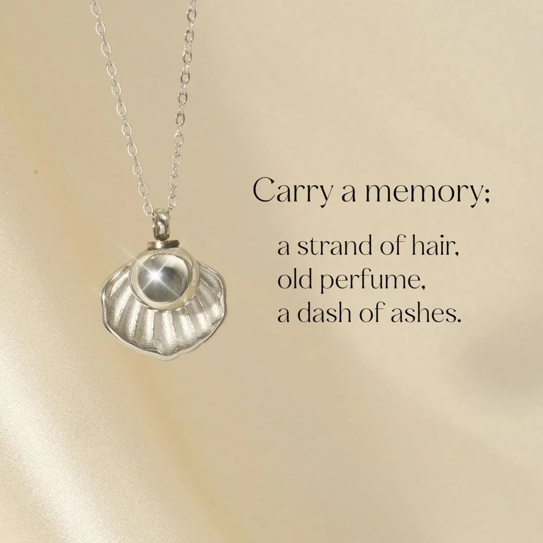 Silver shell-shaped necklace designed to hold human ashes, symbolizing love and remembrance.