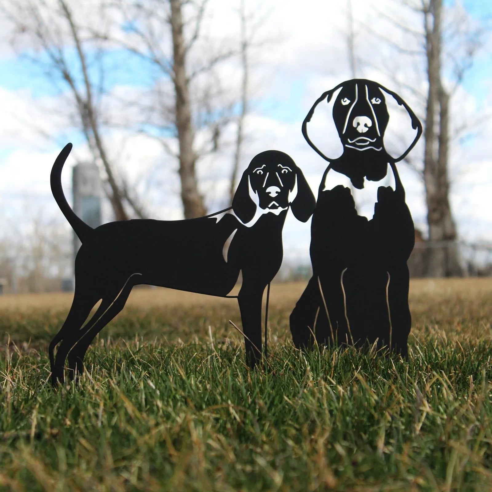 Black metal silhouette of two Treeing Walker Coonhounds standing on grass, showcasing their detailed features and sturdy d...