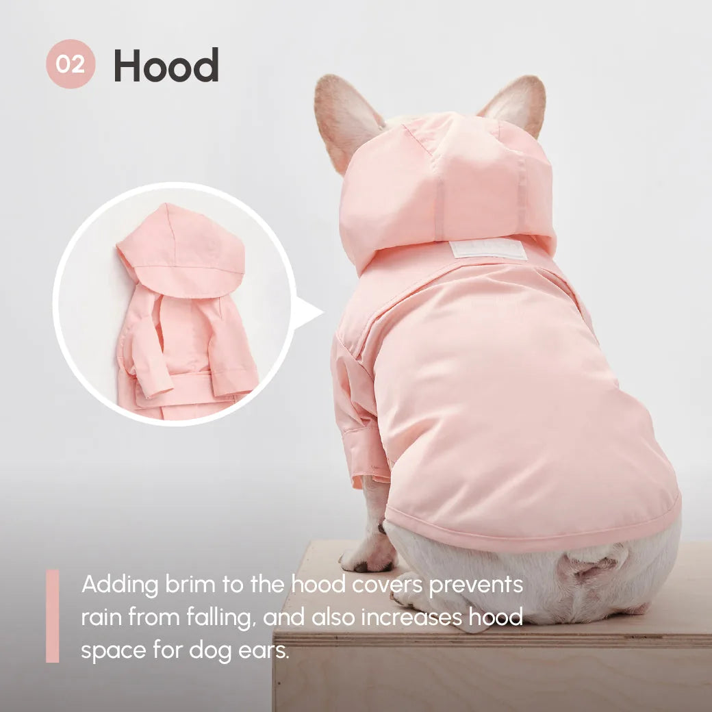 Light pink adjustable velcro raincoat for dogs, featuring a hood with a brim and ear space, designed for quick wear.