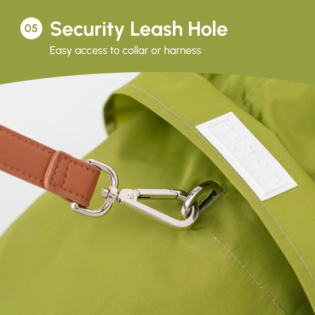 Olive green raincoat showing a security leash hole and a brown strap clip for easy collar or harness attachment.