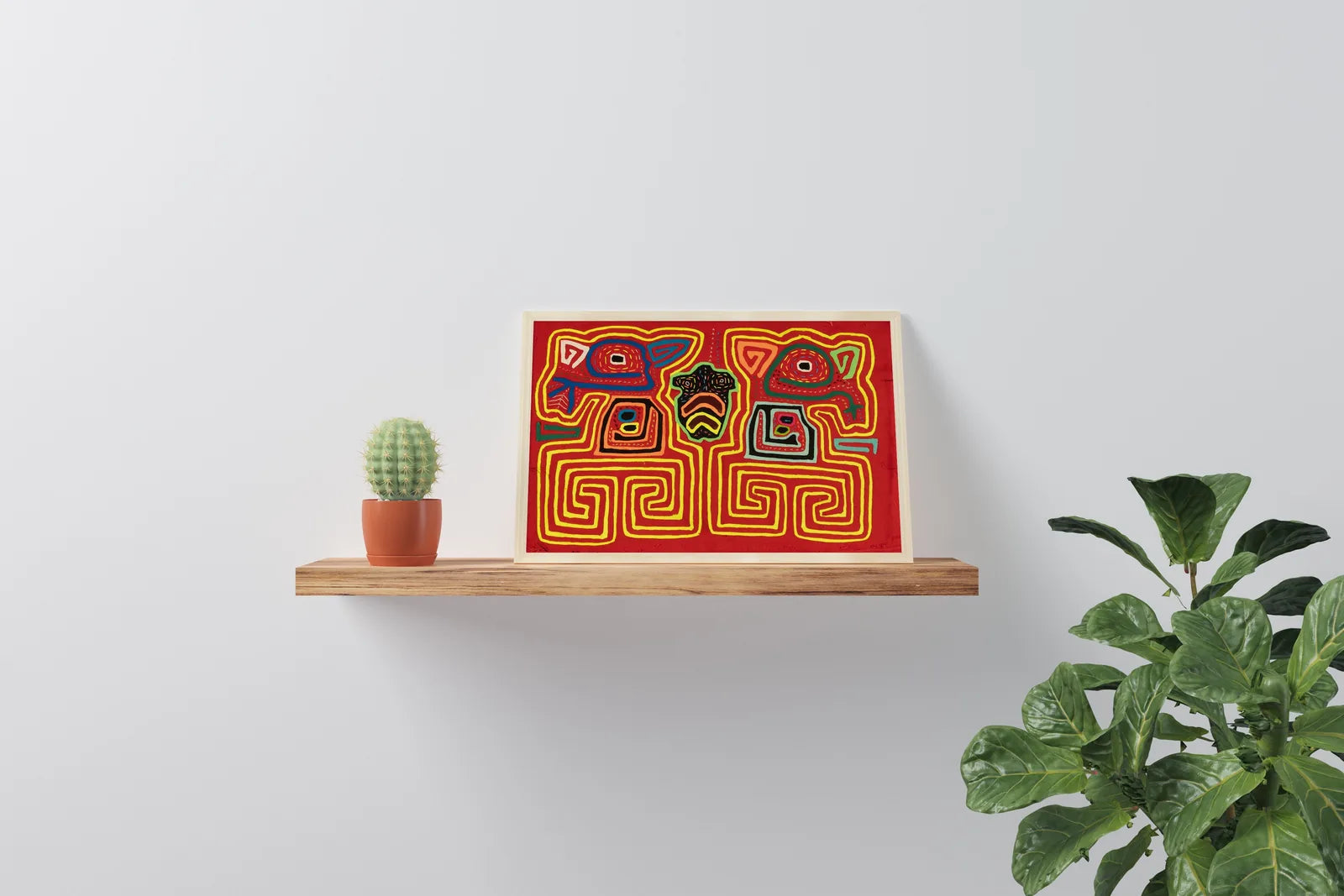 Hand-stitched red Mola tapestry featuring geometric patterns and dog designs, displayed on a wooden shelf with greenery.