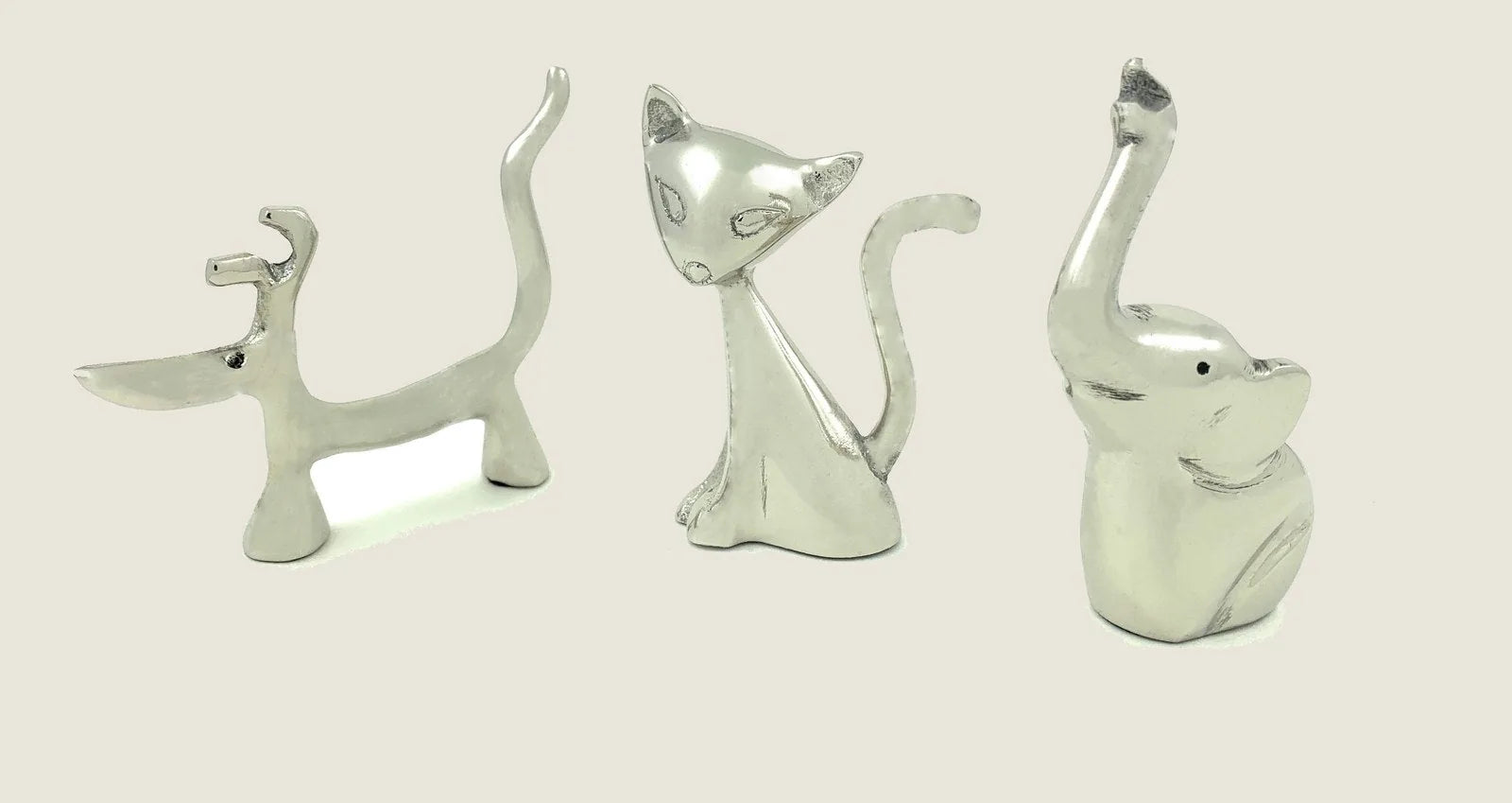 Set of three silver animal ring holders shaped like a dog, cat, and elephant, showcasing a glossy finish.
