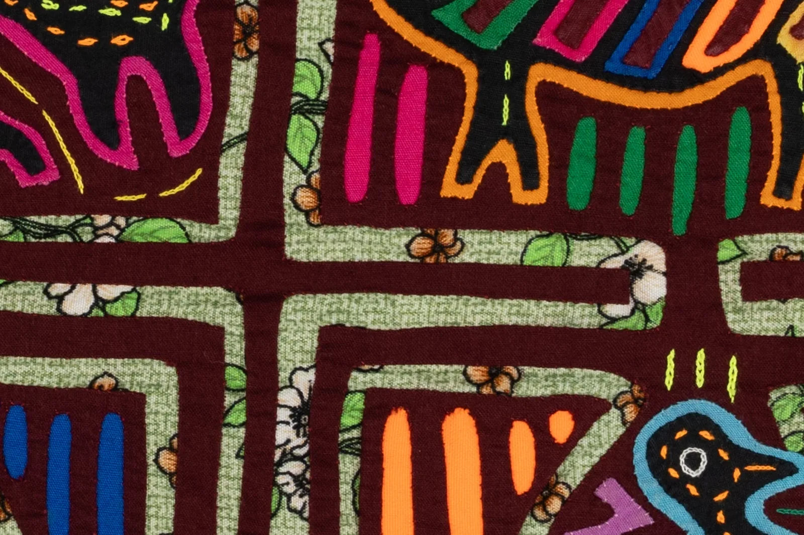 Hand-stitched mola featuring a colorful vintage bird and puppy design against a floral patterned background.