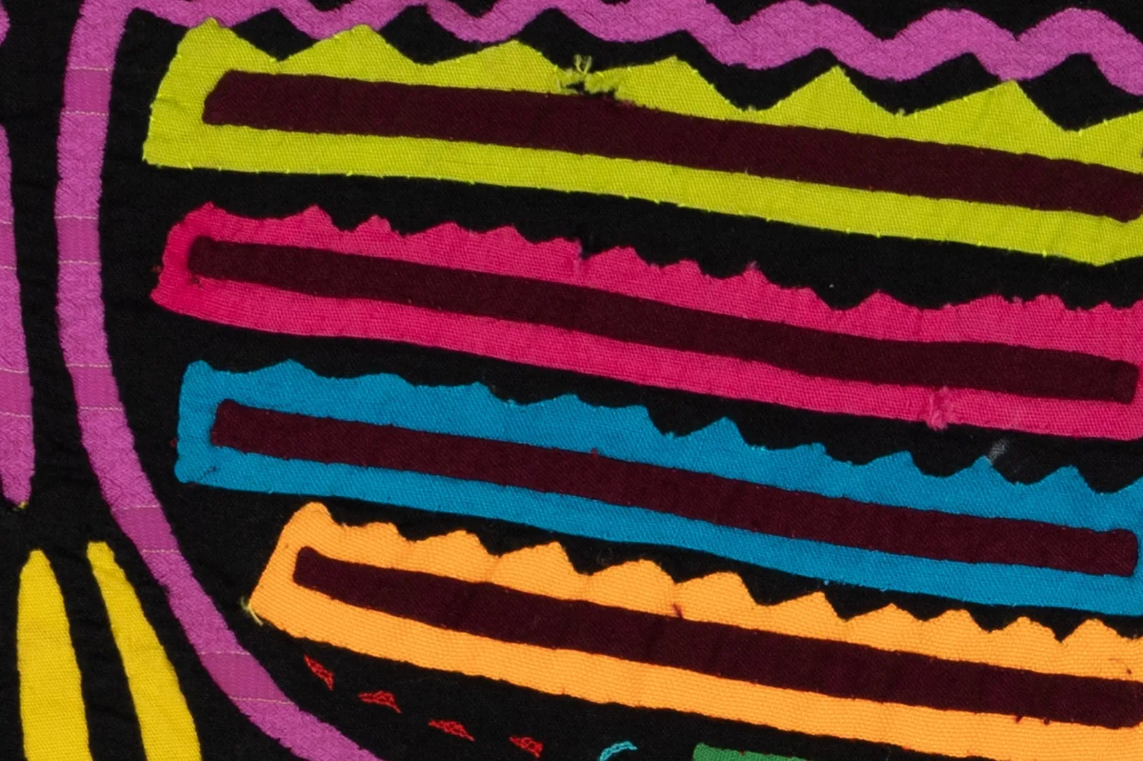 Colorful geometric patterns in pink, green, and blue on a black background, showcasing hand-stitched textile art.