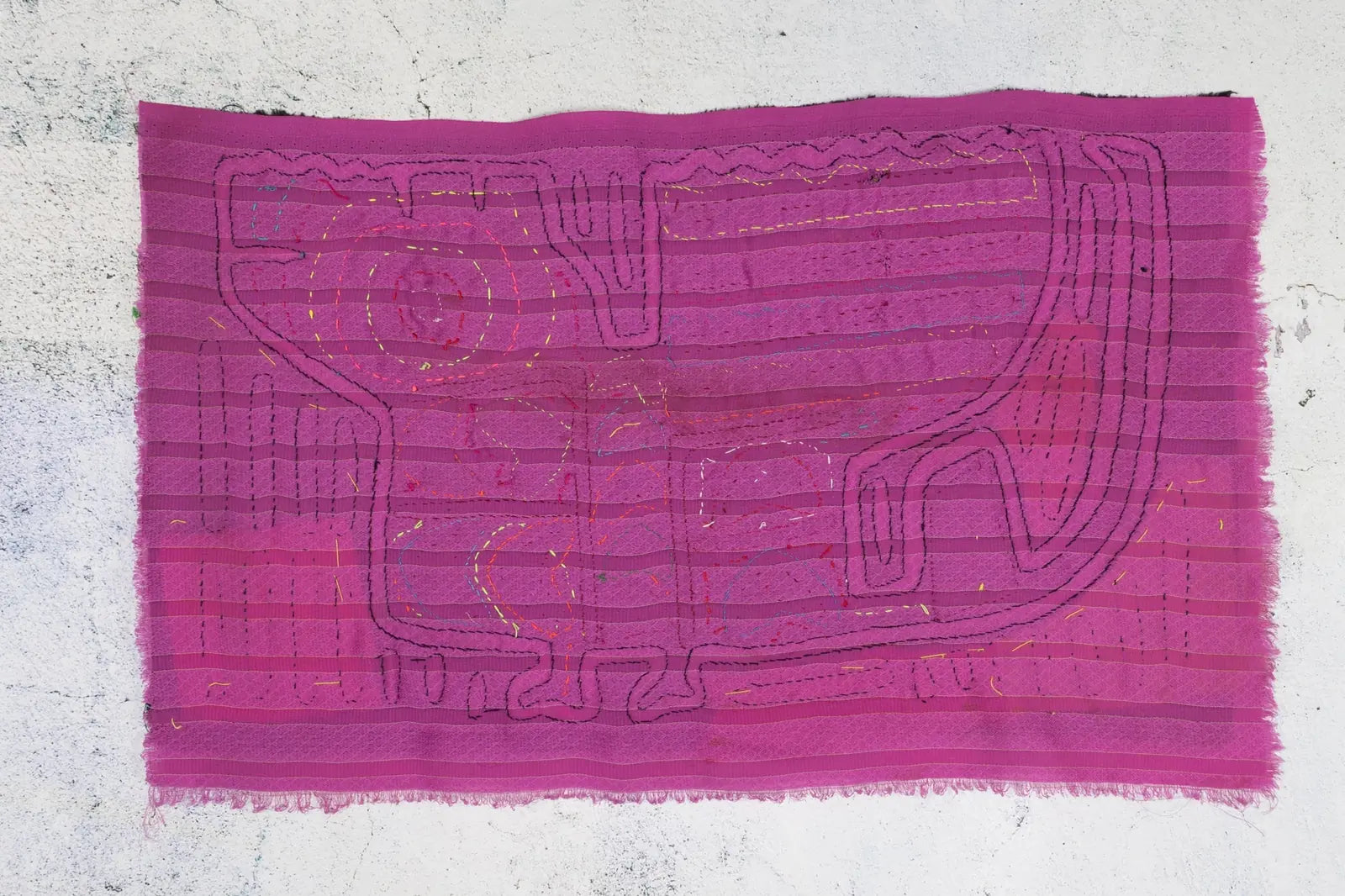 Hand-stitched purple Mola featuring a playful puppy design, showcasing vibrant colors and intricate geometric patterns.