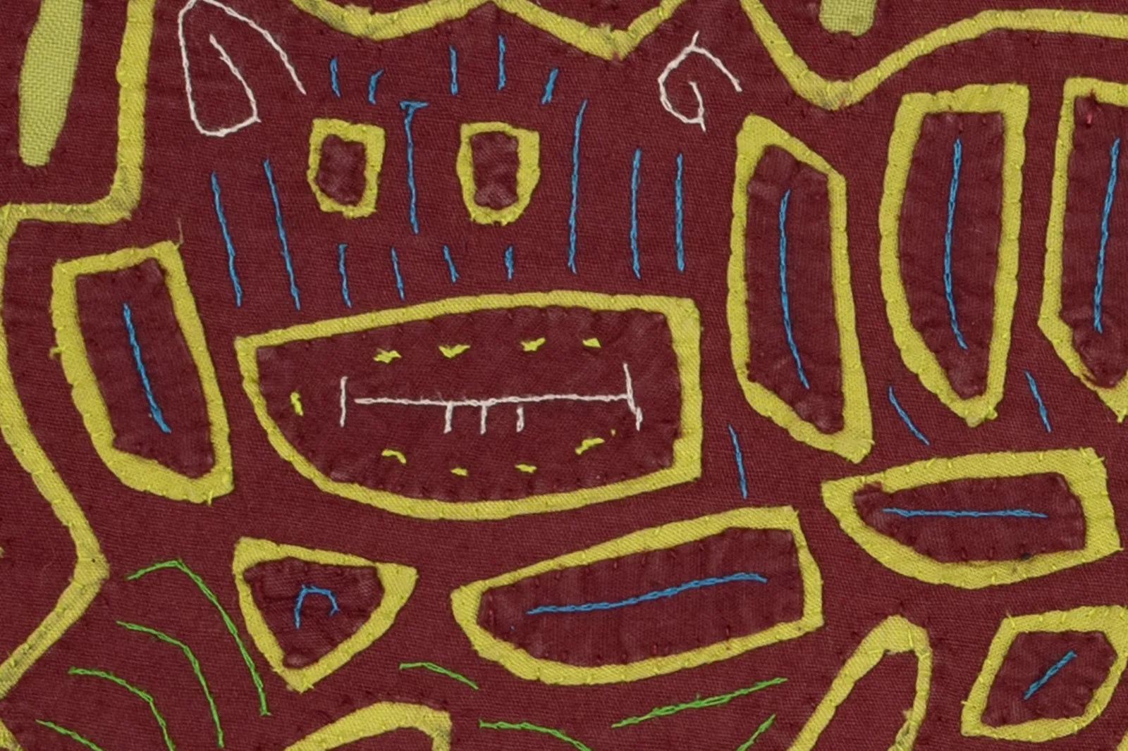 Hand-stitched Mola in vintage burgundy with green and blue patterns, featuring playful dog motifs and geometric designs.