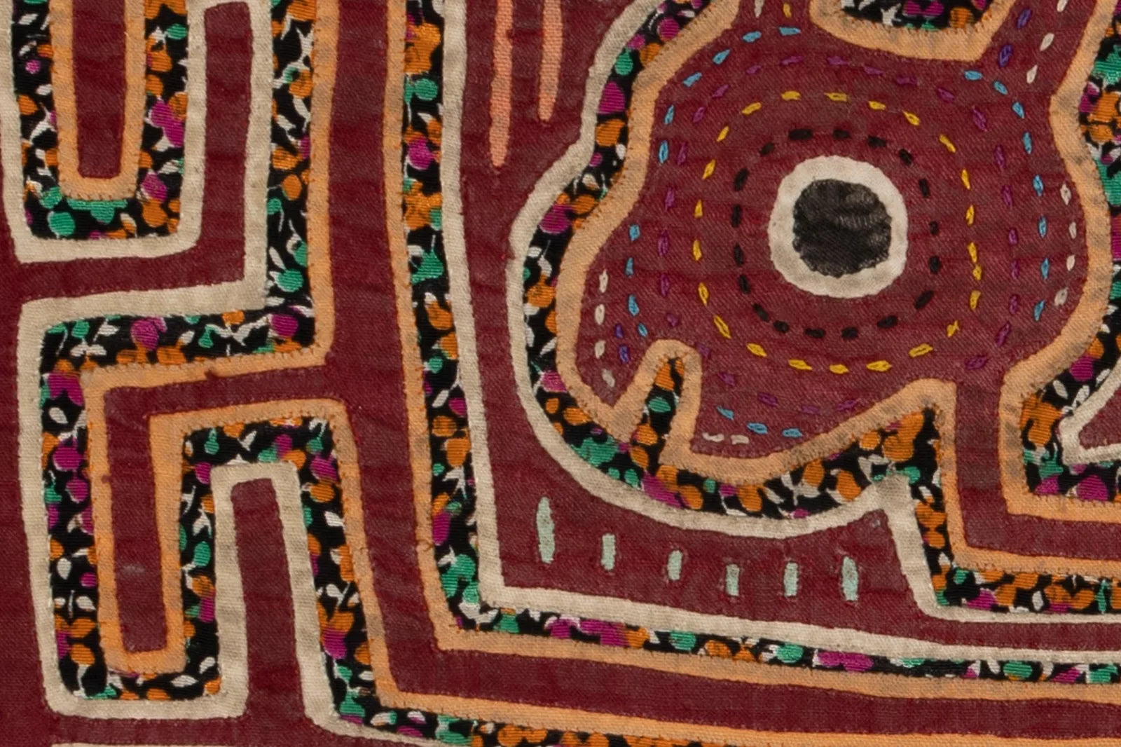 Hand-stitched vintage burgundy puppy design with colorful appliqué detailing on a textile tapestry.