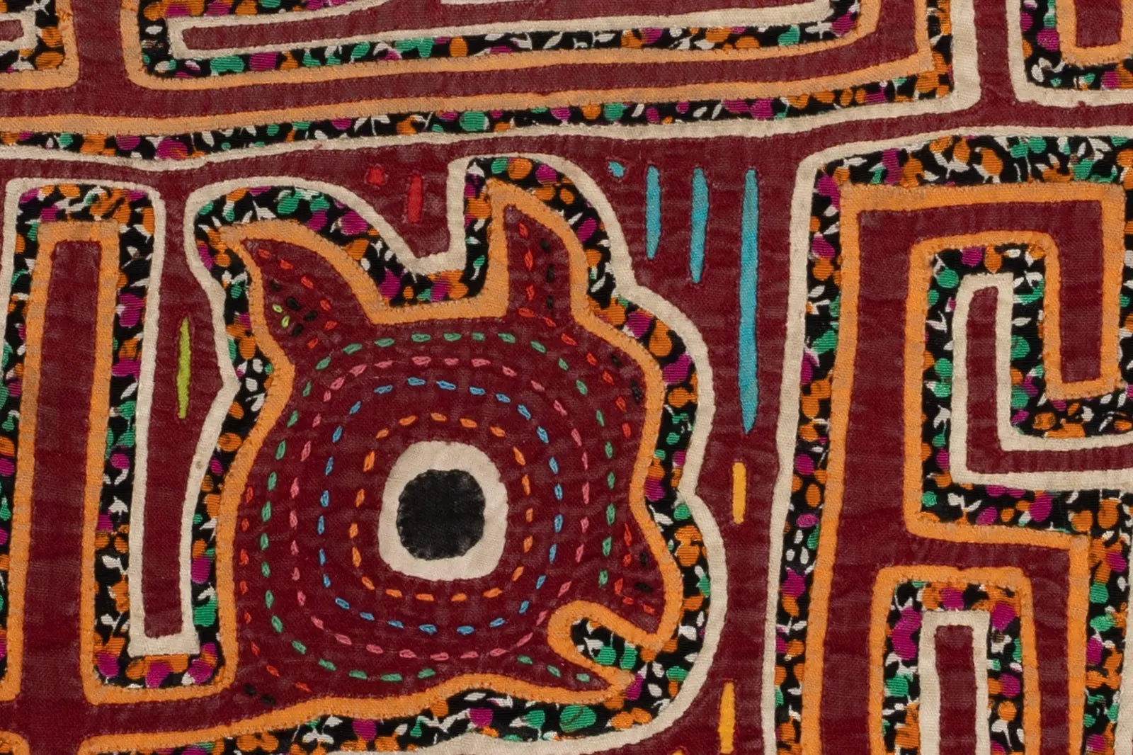 Hand-stitched vintage burgundy puppy Mola with colorful patterns and intricate detailing, showcasing traditional textile art.