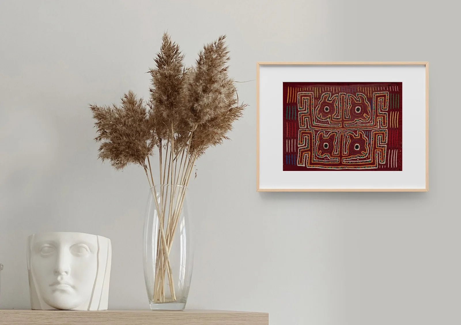 Hand-stitched vintage burgundy Mola featuring a playful puppy design, framed and displayed alongside decorative elements.
