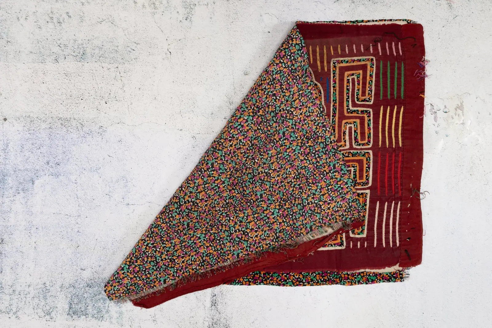 Hand-stitched vintage burgundy Mola tapestry featuring a colorful yapping puppy design with intricate patterns.