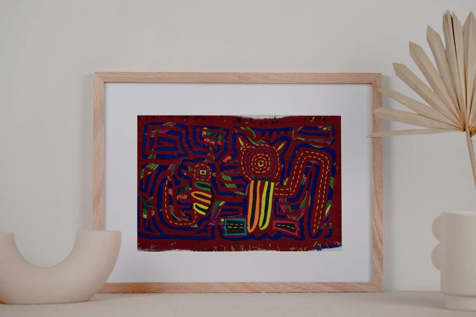 Hand-stitched vintage Panama Mola featuring vibrant geometric designs of a puppy and gecko on a red background.