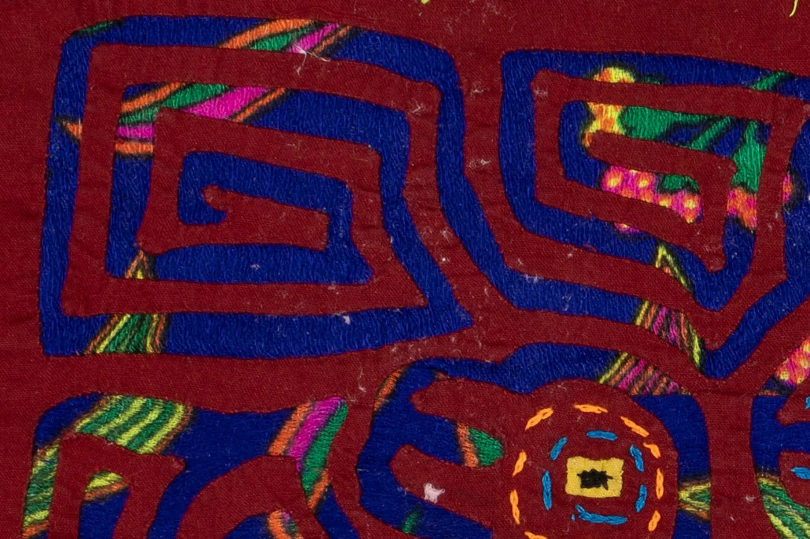 Colorful geometric patterns in rich reds and blues highlight this hand-stitched Panama Mola textile art, showcasing vibran...