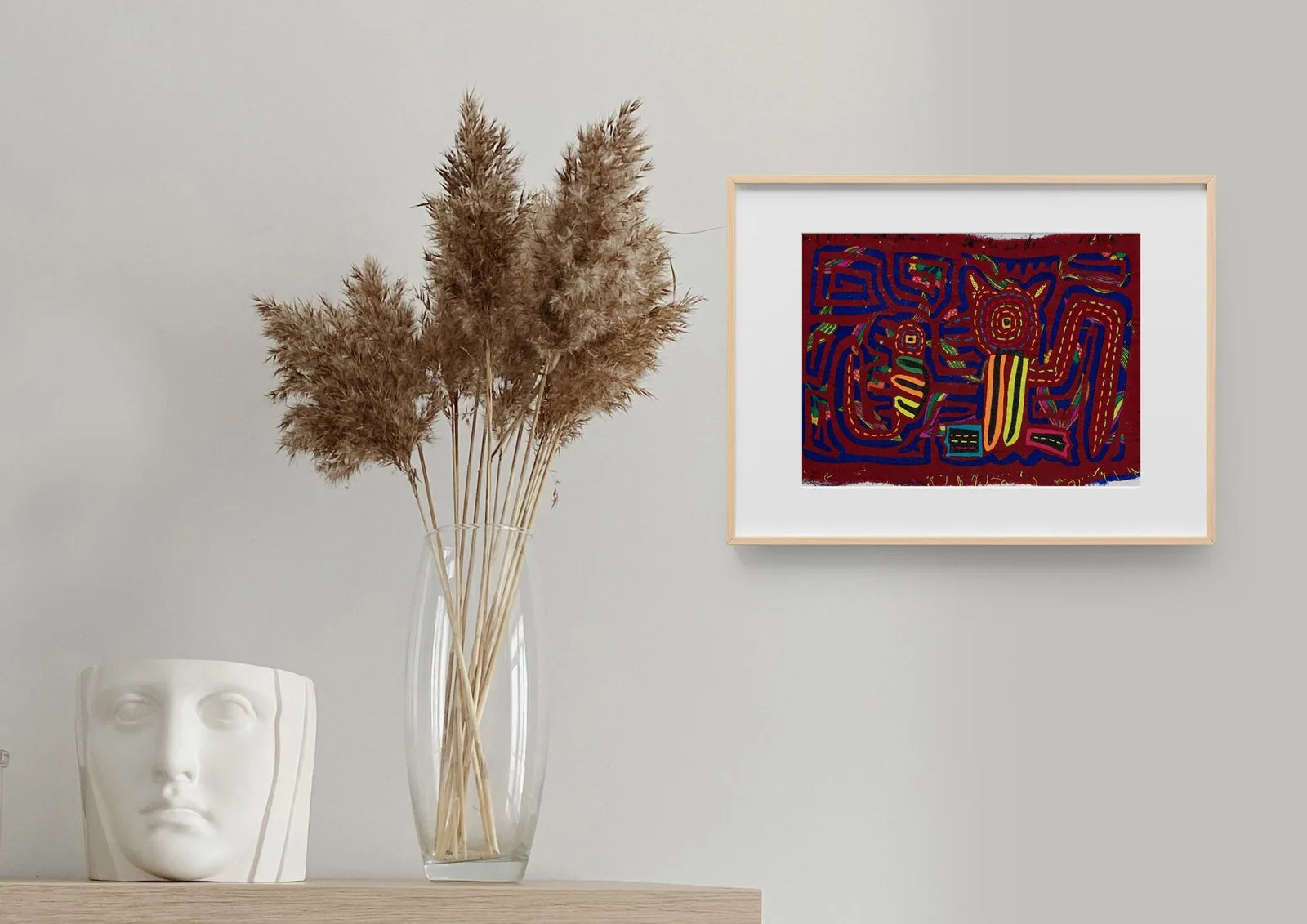 Colorful hand-stitched Panama Mola tapestry featuring geometric dog and gecko designs on a rich red background.