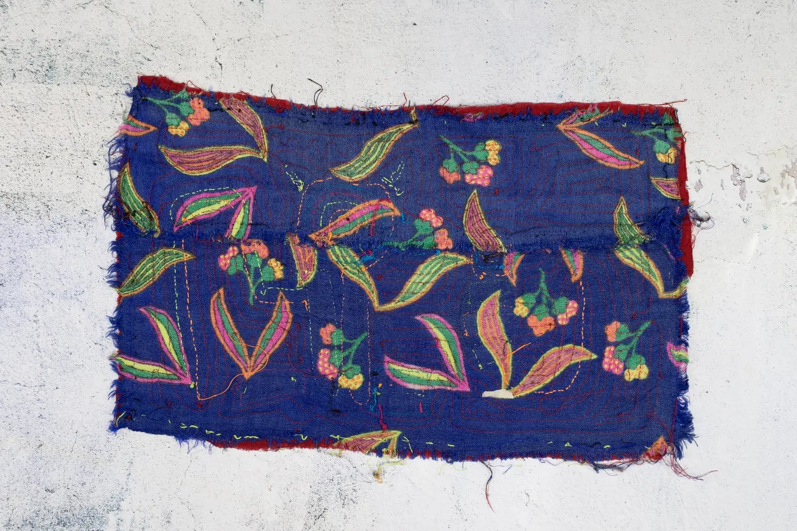 Hand-stitched blue Panama Mola featuring colorful floral patterns, highlighting cultural textile art.