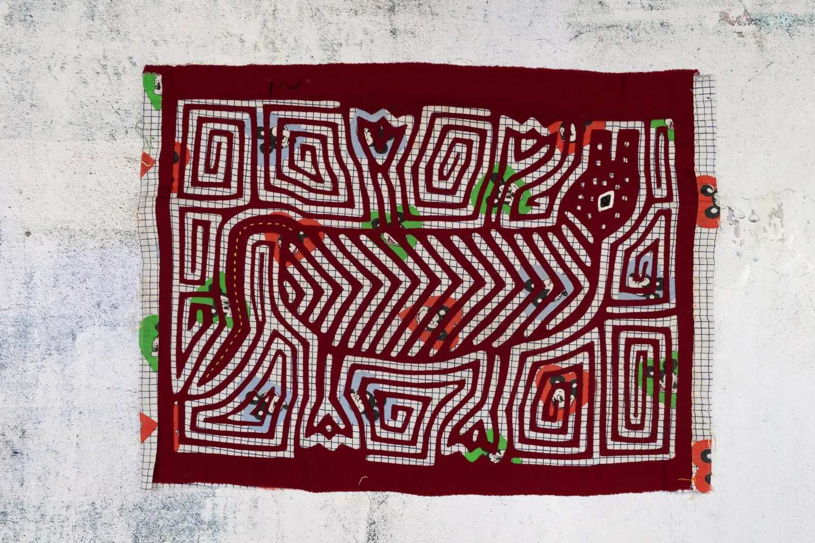 Hand-stitched red tapestry featuring a vintage howling puppy design with colorful geometric patterns.