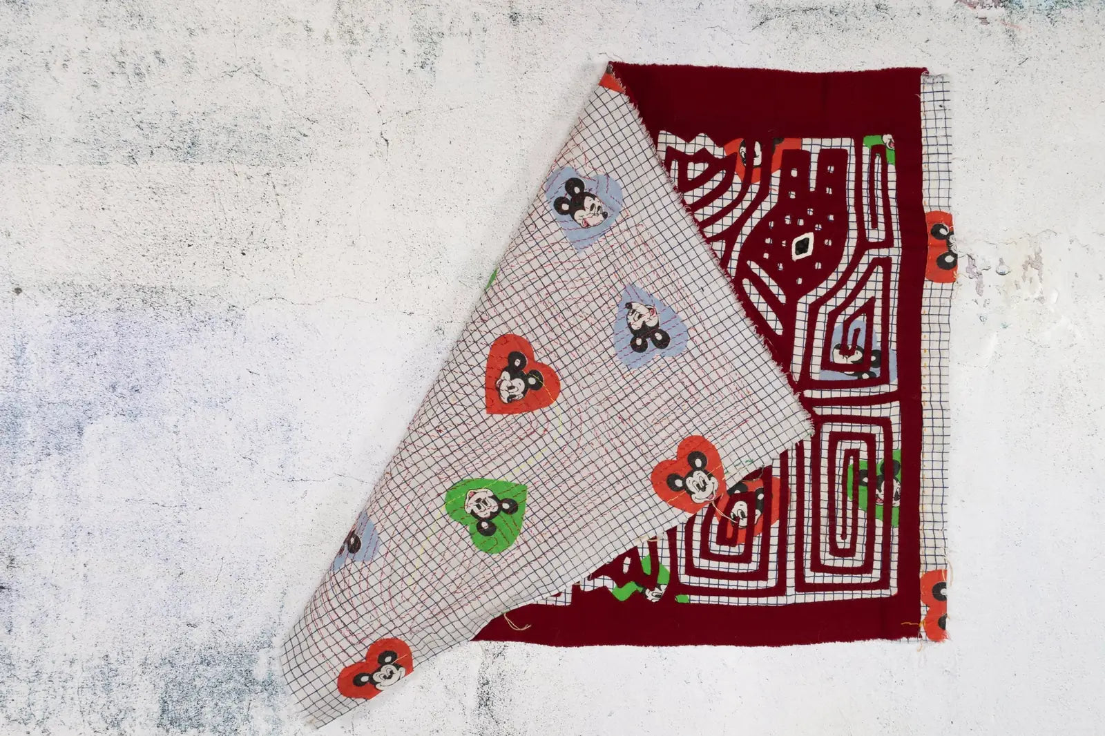 Hand-stitched red and patterned fabric tapestry featuring a vintage puppy dog howling design, showcasing intricate appliqu...
