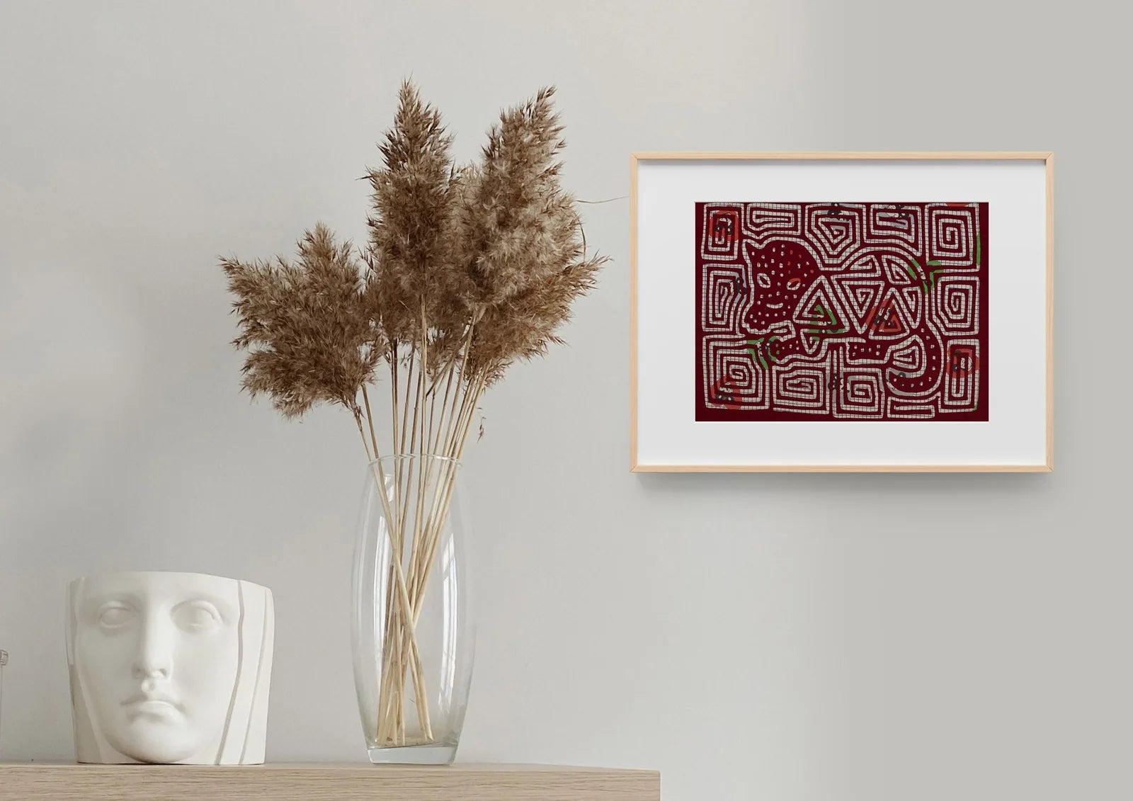 Hand-stitched vintage puppy dog tapestry featuring vibrant red and white patterns, framed and displayed on a wall.