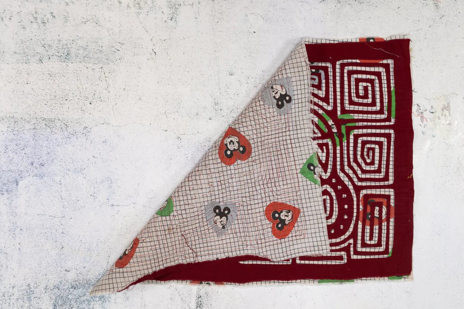 Vintage hand-stitched tapestry featuring vibrant red and playful patterns, showcasing a unique puppy dog design.