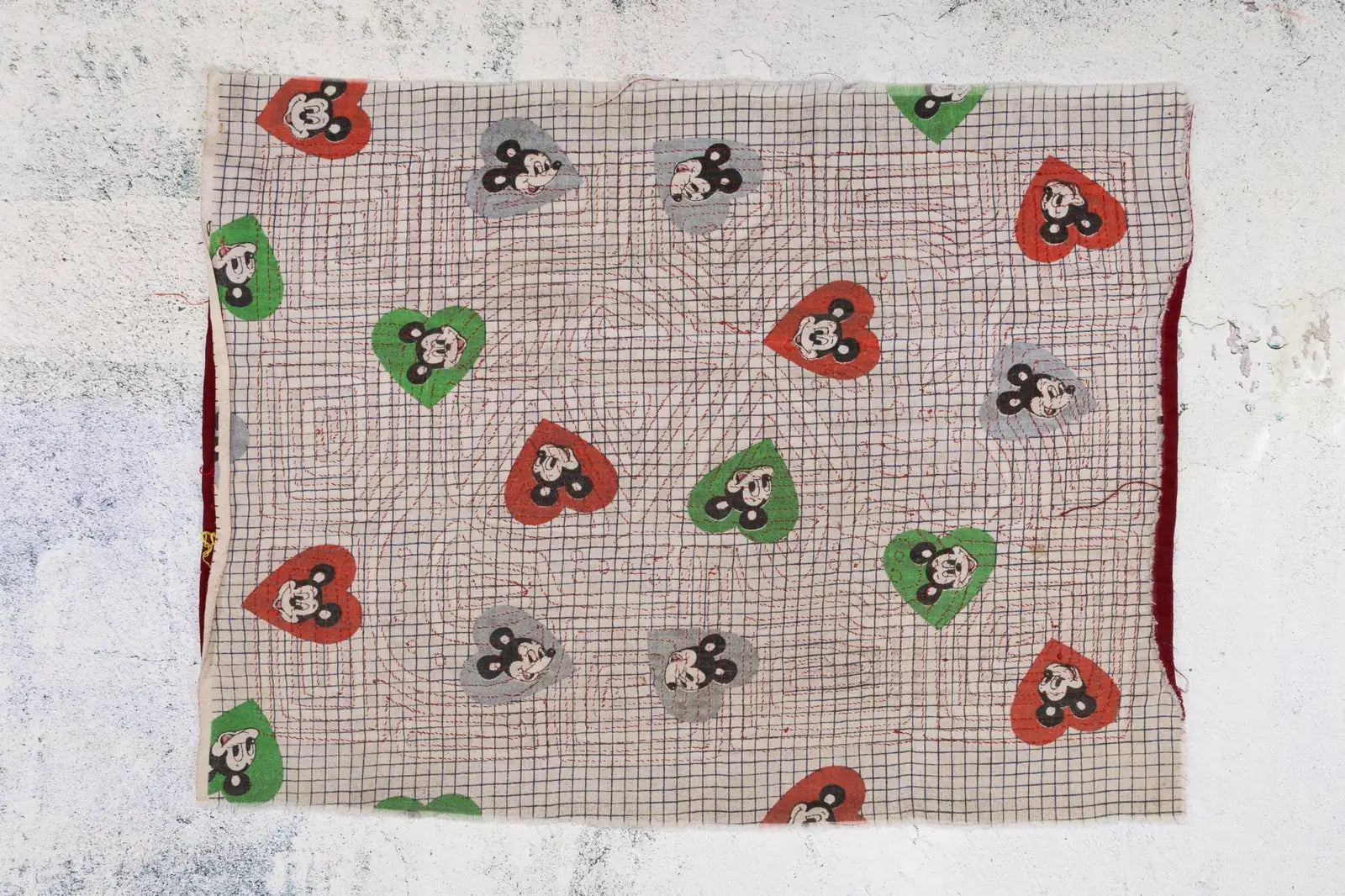Hand-stitched vintage tapestry featuring colorful hearts and playful puppy motifs on a textured background.