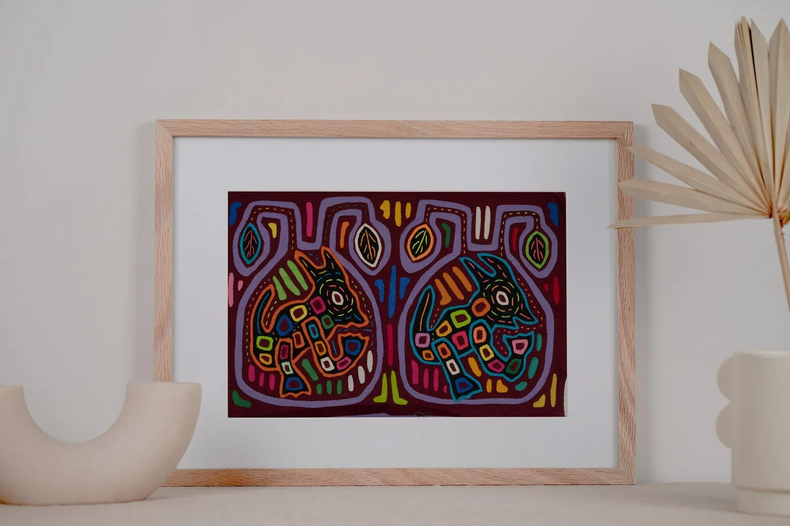 Hand-stitched colorful mola tapestry featuring playful dog designs in vibrant hues on a rich dark background.