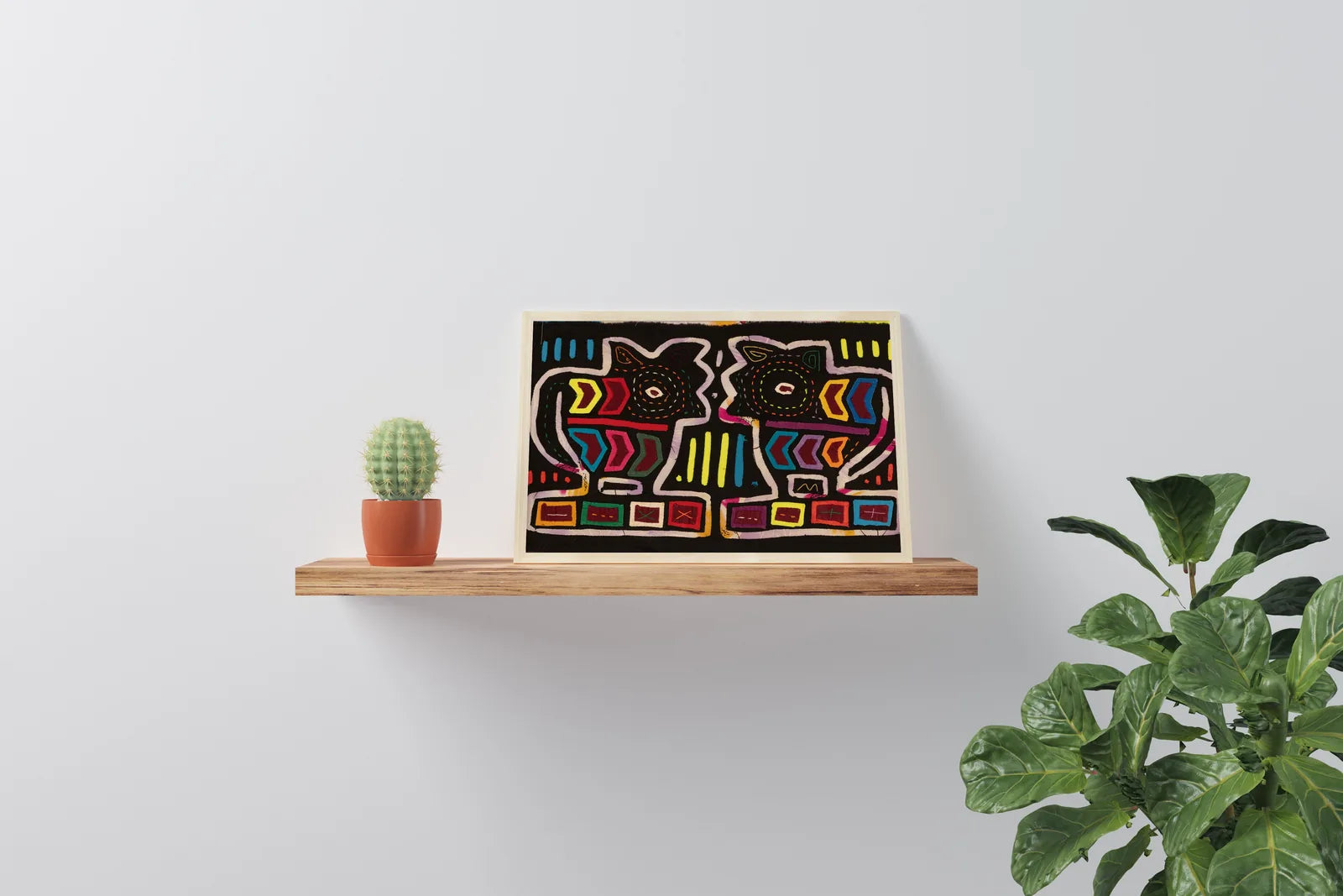 Hand-stitched vintage mola featuring two colorful puppy dog designs on a black background, framed on a wooden shelf.